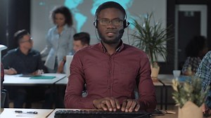 Worker in front of the computer with headset - Free Stock Video