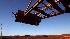 High definition footage of industry rope access technician inspector abseiling from working at height during concrete spalling inspection on counterweight construction site