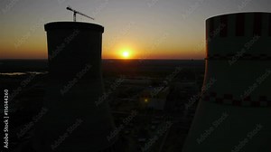 The cooling system of a nuclear reactor. Dark shape of cooling towers at sunset