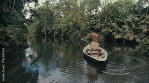 Huaorani boy in a canoe hunting in the rainforest
