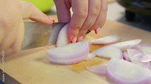 Woman knife red onions on a wooden board. Time laps