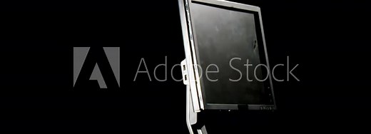 Hand holding a big hammer, hitting and smashing a computer display, isolated on a black background, slow motion steady shot. People and technology, mutual destruction concepts.