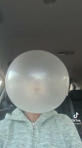 Woman blows massive bubblegum bubble and it explodes all over her face