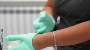 Female dentist's hands put on sterile protective gloves in modern dental office. Doctor woman puts clean gloves on hands before examining patient. Surgeon prepares for medical procedures. Close-up. Stock Video