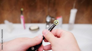 Replacing worn out bristles of electric toothbrush. View of old ultrasonic tooth brush head in bathroom switched for a new one. Smart sonic toothbrush with colorful bristles for cavity prevention.
