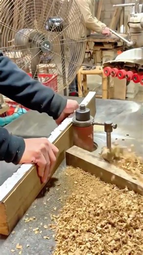 A Professional Woodworker Shaping Timber Using a High Precision Spindle Shaper Machine