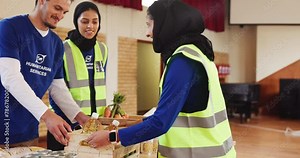 Volunteer, humanitarian and charity donation with teamwork for community service in crisis, collection or outreach. Man, women and giving back project in hall for homeless nonprofit, food or help