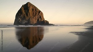 Haystack Rock Cannon Beach Dawn 4K UHD. Sunrise at Haystack Rock in Cannon Beach, Oregon as the surf washes up onto the beach. United States. Stock Video