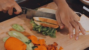 Download Detail of female hands adding salami on a sandwich woman making hot sandwiches for breakfast in a sandwich maker for free