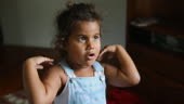 Happy singing and dancing young Australian Aboriginal girl playing