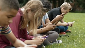 Teens on cell phones - Teenagers all texting or playing games on their phones, ignoring each other