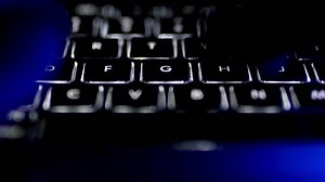 Typing on Illuminated Computer Keyboard at Night