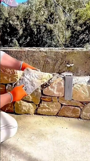 Mason Placing a Large Natural Stone to Construct a Rustic Dry-Stack Wall