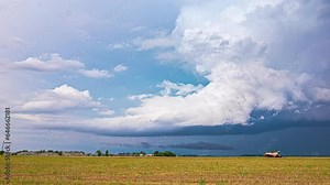 Powerful rain clouds forming storm above rural landscape, time lapse