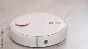 Turning on Robot vacuum cleaner and vacuuming the floor in the room. Smart home with automated devices that simplify life. A smart vacuum cleaner cleans the floor. High quality 4k footage
