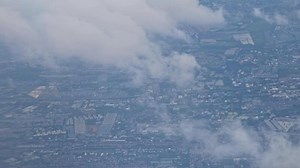 Download Aerial cityscape with cloudy sky and overcast atmosphere, urban residential buildings and green spaces, sprawling city view from above showing for free