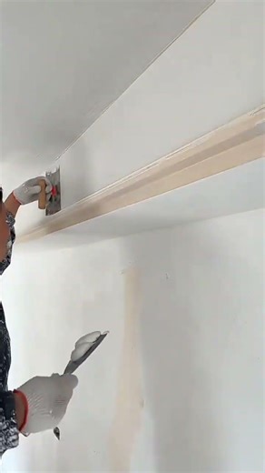 Carefully smoothing ceiling corners for perfect finish