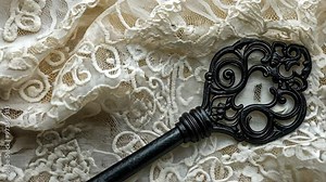 Exploring the intricate design of an antique key on delicate lace fabric in a vintage setting