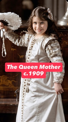 Elizabeth Bowes-Lyon in 1909, later known as Queen Elizabeth The Queen Mother. Here she is aged about 9, dressed in a theatrical costume and holding a feather fan, photographed during a period when costume and role-play portraits were especially popular for children of upper-class families. This image shows her long before royal life, when she was still simply Elizabeth Bowes-Lyon, growing up in a large aristocratic Scottish family. She would later become Queen Consort to King George VI and one 