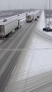 A terrifying multi-vehicle pile-up unfolds on a treacherous, icy highway bridge during a heavy snowfall. Caught on a stationary traffic camera, the footage shows cars losing control and colliding in a chaotic chain reaction, with a semi-truck jackknifing after a sedan spins out while attempting to merge. Multiple vehicles slide uncontrollably across the slick road, creating a scene of absolute mayhem and destruction amidst the winter weather. | Extra Give Back