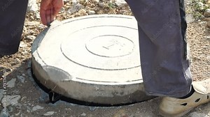 Manhole, Open, Worker - Man opens sewer manhole on gravel road maintenance work conducted for system inspection.