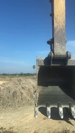 Excavator in Action: Lifting Soil at Construction Site
