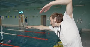Coach practise with swimmer in the indoor swimming pool