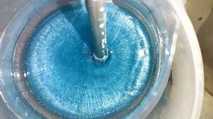 Mixing epoxy resin with blue pigment. Epoxy bubbles are evaporates at high temperature. Making coasters and wooden tables with epoxy. Resin epoxy is new way of doing art. Filmed in 4k