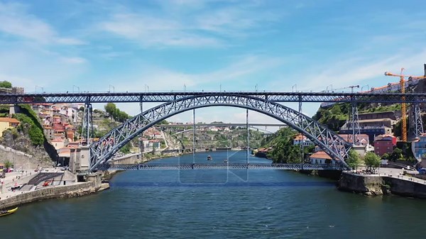 Wide view of the iconic Dom Luis I Bridge spanning the Douro River in Porto, Portugal, with colorful buildings and clear blue sky Stock Video Footage - Alamy