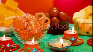 Colorful Diwali oil lamps, Deepavali oil lamps lighted in beautiful formation with bowls full of different Diwali sweets. Decorative Colorful Diya lamps lit during Diwali celebration