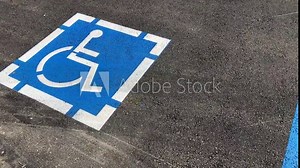 ADA handicapped sign with handicapped wheelchair symbol marks accessible parking space
