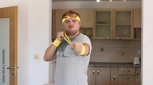 A playful handsome man stretches a sports elastic band and it jumps off his hand and hits him in the face. Sports fashion accessories.