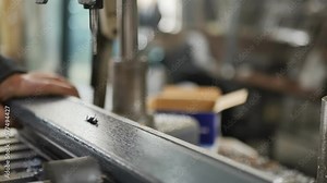 Production process of plastic windows. Drilling oval holes in a PVC profile using an industrial drilling machine with manual worker control. Production worker drills holes in PVC