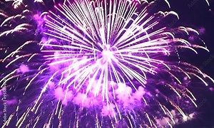 A close-up of a single firework igniting and exploding in slow motion, with the camera tracking the sparks as they radiate outward