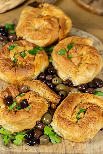 Greek Eliopites – Flaky Phyllo Spirals with Olives, Herbs & Feta ✨ If you love olives, feta, and buttery phyllo, you’re going to fall in love with these savory Greek pastries! Fresh herbs, creamy feta, and briny olives are wrapped into delicate phyllo spirals and baked until golden and crisp. Perfect as an appetizer, snack, or part of a mezze spread, they’re bursting with Mediterranean flavor! Make a batch for your next gathering or enjoy them with a cup of coffee for a taste of Greece anytime.