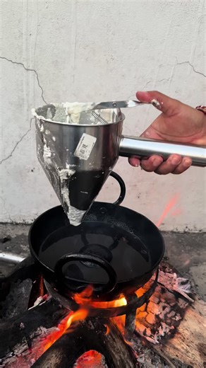 Traditional Cooking Process with Cauldron Over Fire