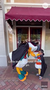 Young fan shakes a tail feather with his favorite, famous Disney duck
