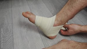 Compression ankle stabilizer elastic bandage. Leg injury and sprain of young sports man