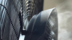 Misting Fog system, electrical fan and air humidifier spraying water under high pressure to cool the environment in summer, close up slow motion