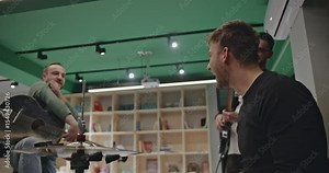 Music band practicing together before a concert. Drummer, guitarist and acoustic guitarist playing instruments and having fun.