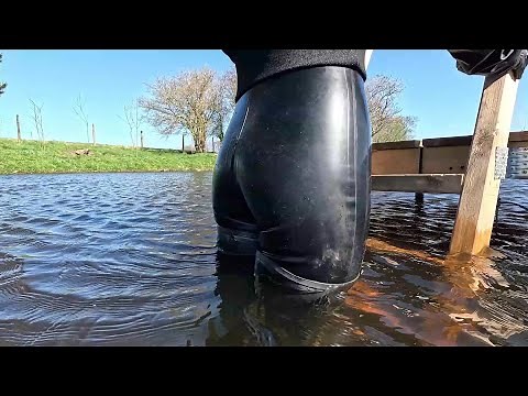 Video 108 - Back to Black - Taster (latex rubber catsuit, Acquo thigh high boots, swim, pond, mud)
