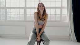 Joyful Young Woman Smiling in a Bright Modern Room. A cheerful young...