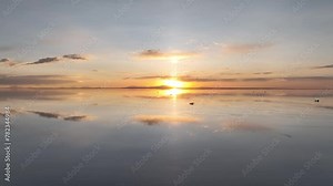 Salar de Uyuni in Bolivia during sunset. Aerial image taken with a drone. Uyuni Salt Flats. Altiplano, Bolivia. Rainy Season. Tunupa Volcano. Clouds Reflection on Water in Lake Surface
