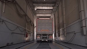 Heavy dump truck moves through the factory workshops to load raw materials.