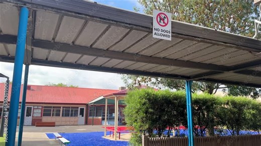 “No dogs allowed” sign mounted under a covered walkway in a public primary school campus in Australia. The sign indicates school safety rules and restricted access for pets within the school grounds.