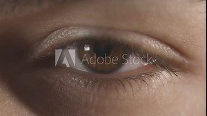 Macro detail of a brown eye with long lashes. Opening and closing of the eye. Pupil dilation reaction to light.