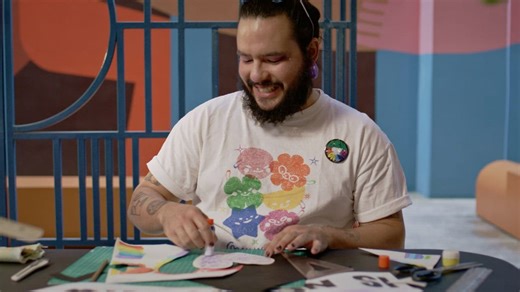 Happy individual pasting a large heart on a Pride poster  - Free Stock Video