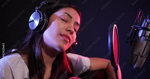 Asian woman performing guitar acoustic solo intro in the recording songs in studio.