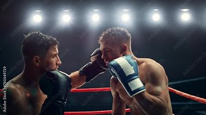Cinematic Super Slow Motion Sports Footage with Two Professional Boxers Fighting in a Ring. Male Athlete Punching the Opponent in the Face. Sweat Spraying Everywhere From the Heavy Impact