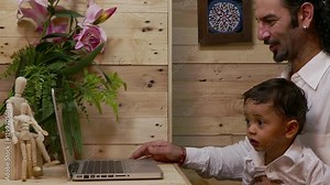 father teaching his son on laptop baby learning in computer with his father